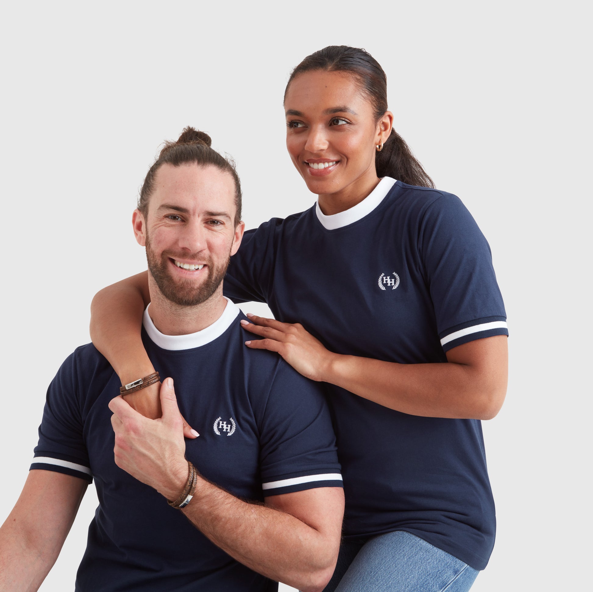 Two models wearing a brown double wrap leather bracelet with a metal clasp depicting the Help for Heroes logo