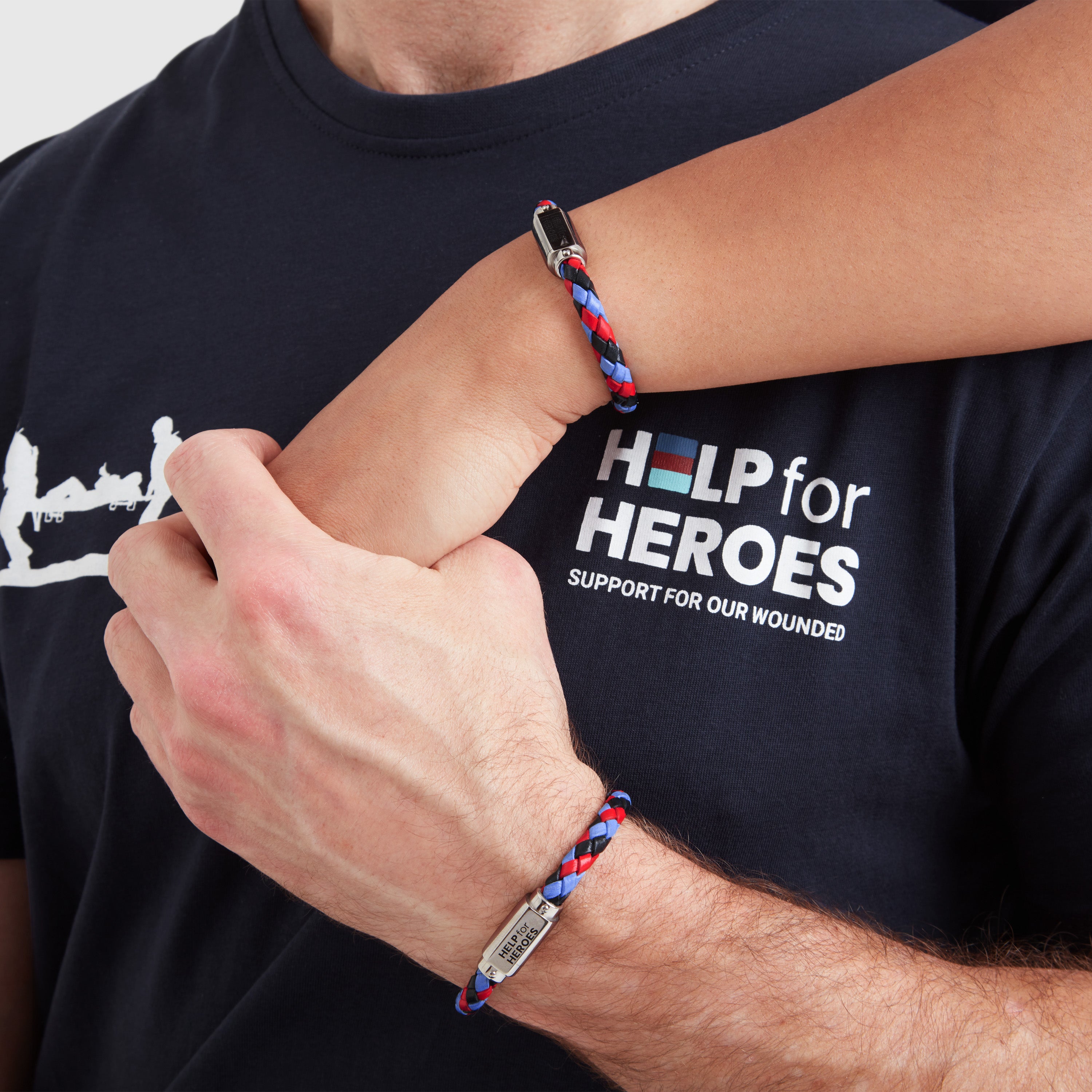 A model wearing a tri-coloured leather ID bar bracelet, with a metal clasp featuring the Help for Heroes logo