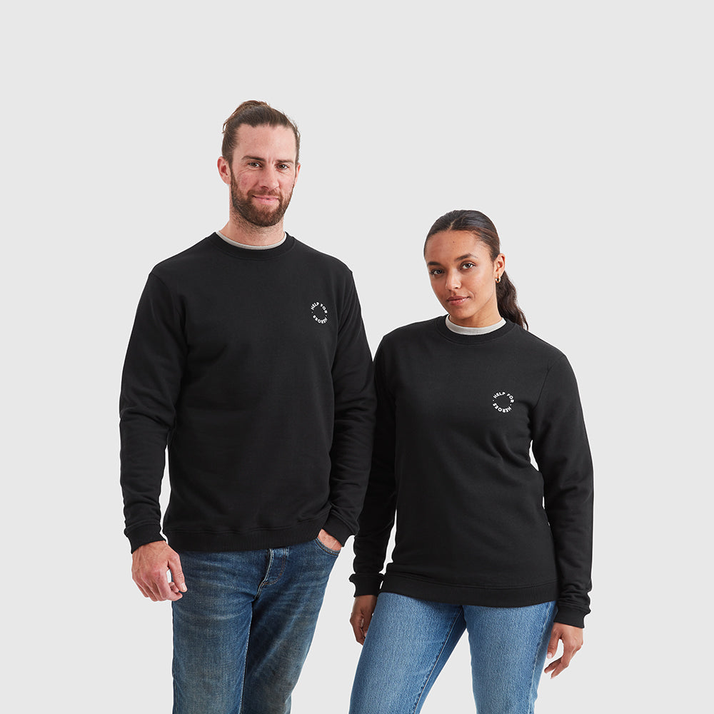 Two models wearing black sweatshirt which features a large circular Help for Heroes logo printed on the back and smaller logo printed on the chest