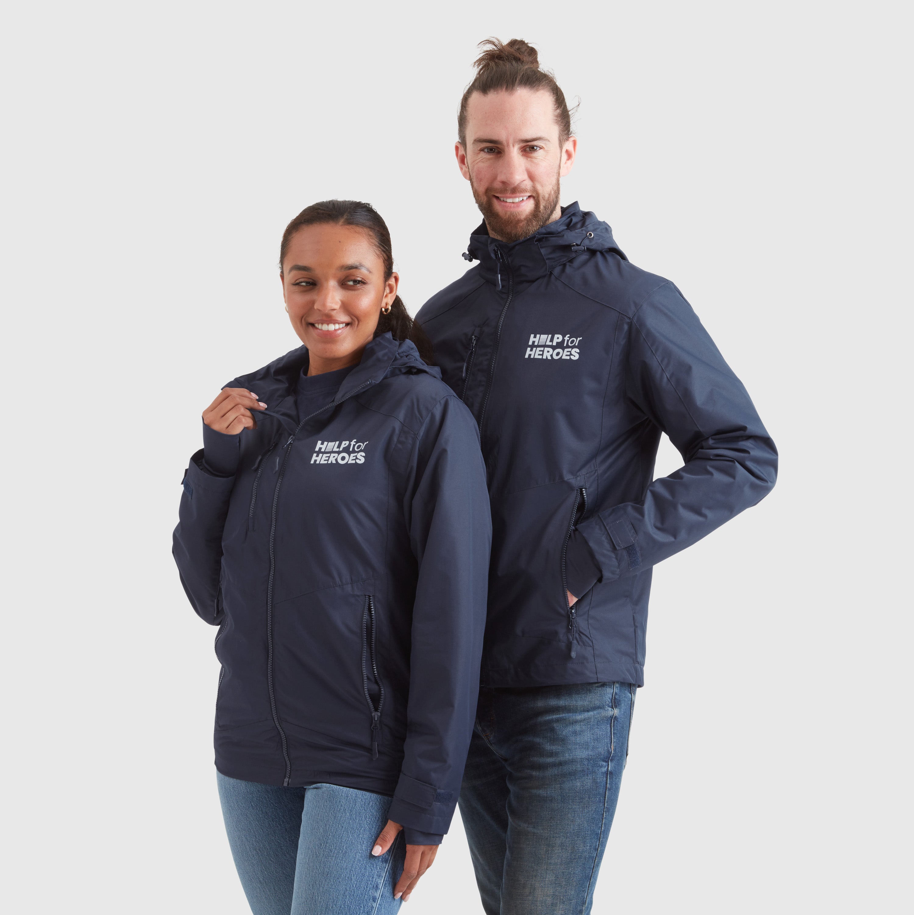 A male and a female model wearing navy waterproof jackets with Help for Heroes logo on the chest