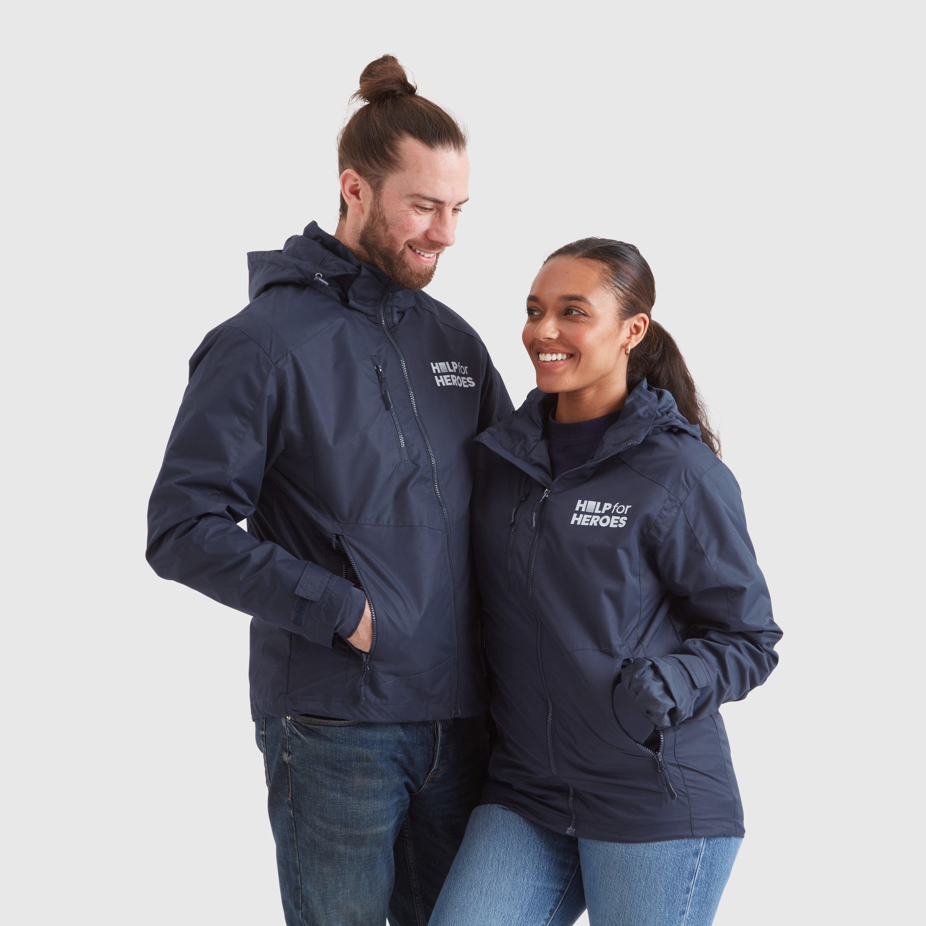 A male and a female model wearing navy waterproof jackets with Help for Heroes logo on the chest