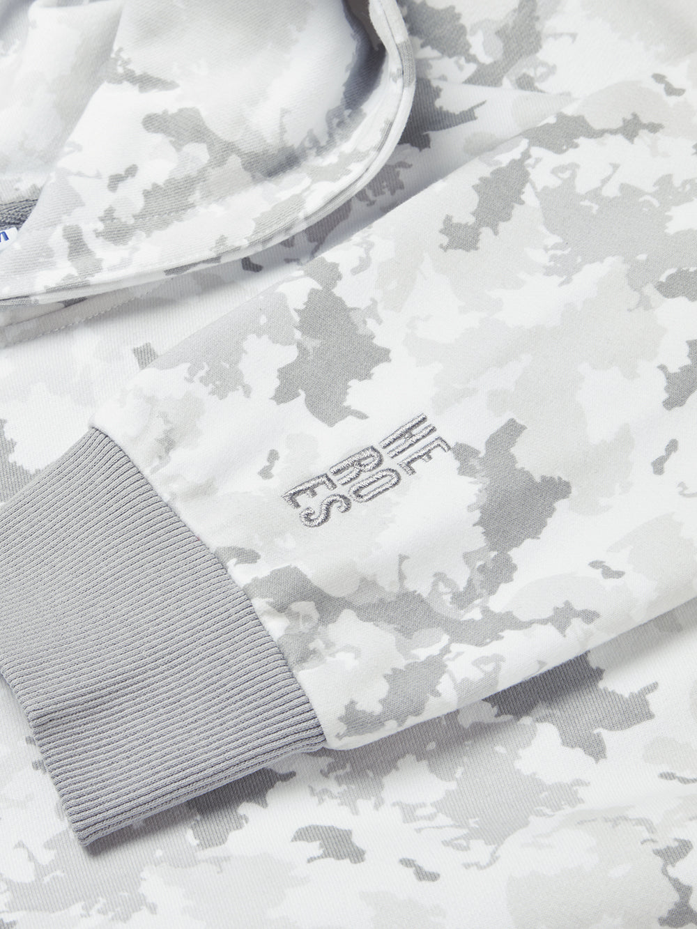 Close up image of embroidered Help for Heroes stacked logo on the sleeve of relaxed fit grey camo pullover hoodie