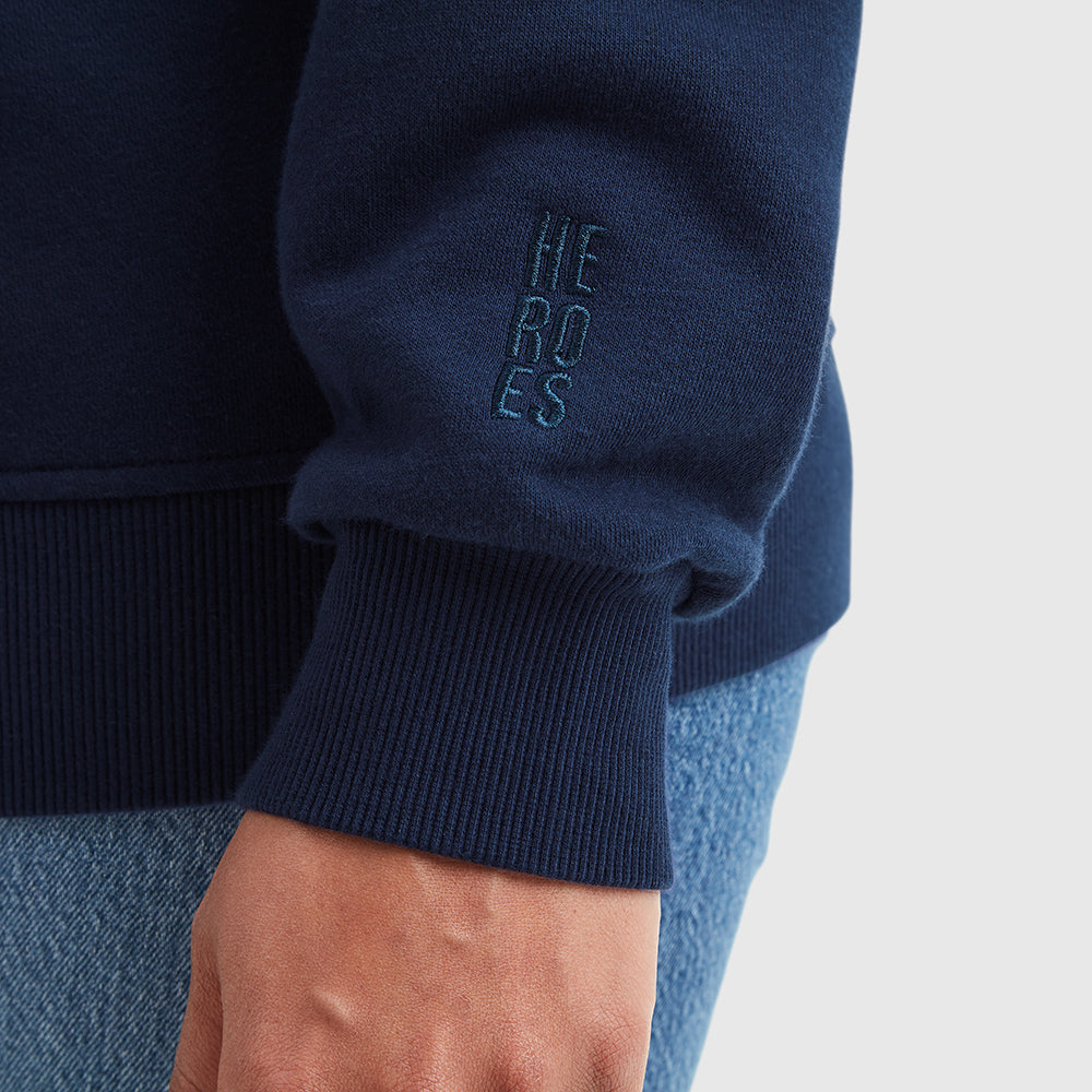 Close up image of embroidered Help for Heroes logo on sleeve of navy zipped hoodie