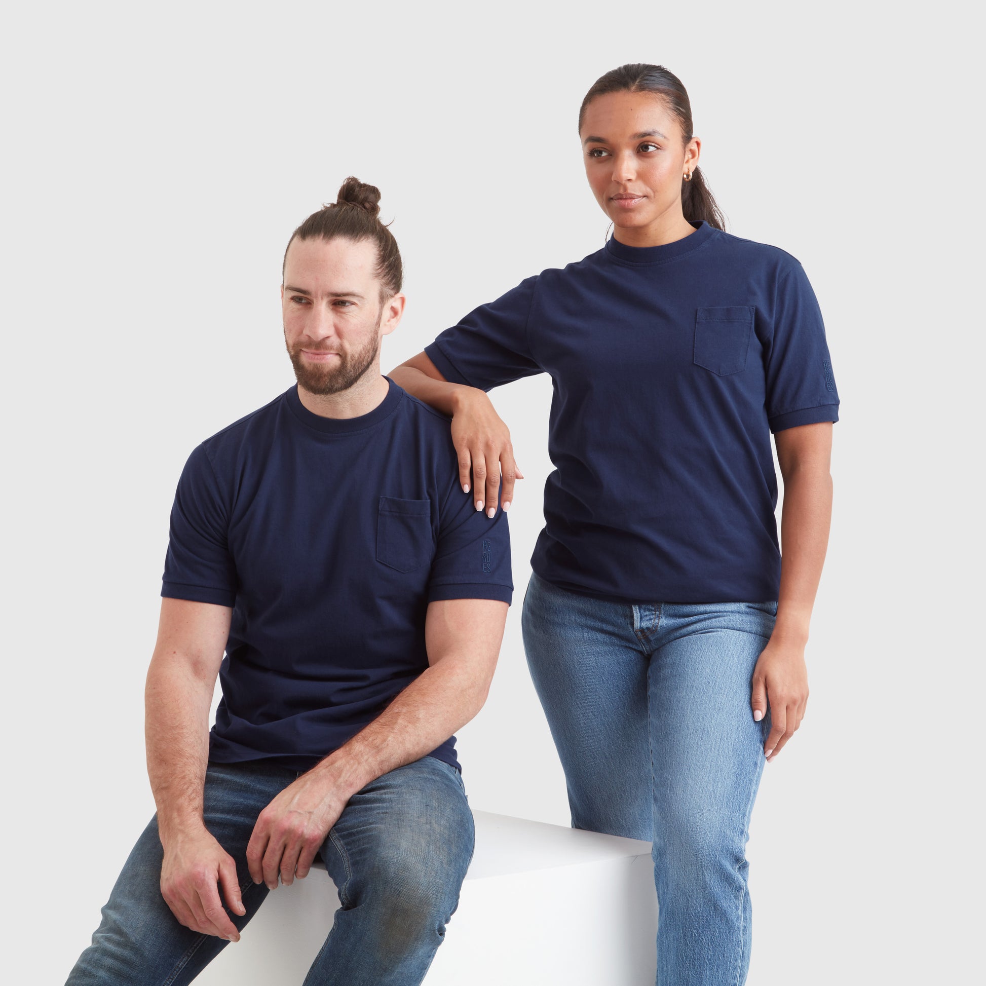 Two models wearing washed navy blue t-shirts with a chest pocket and a subtle Help for Heroes embroidered logo on the sleeve