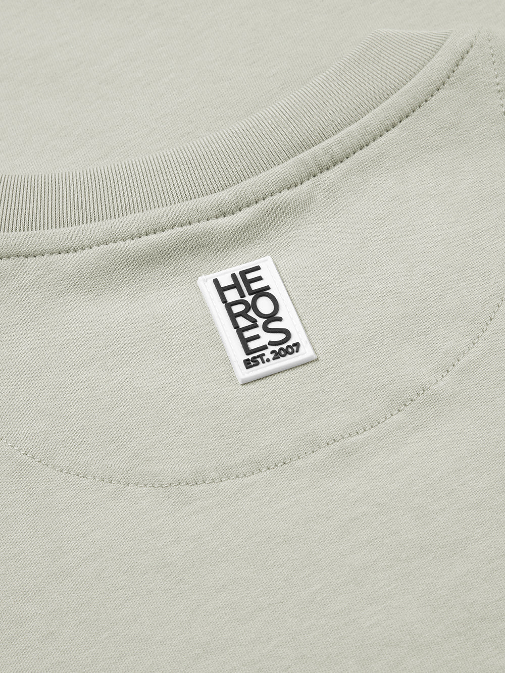 Close up of rubber Help for Heroes logo on back neck of grey crew neck tshirt