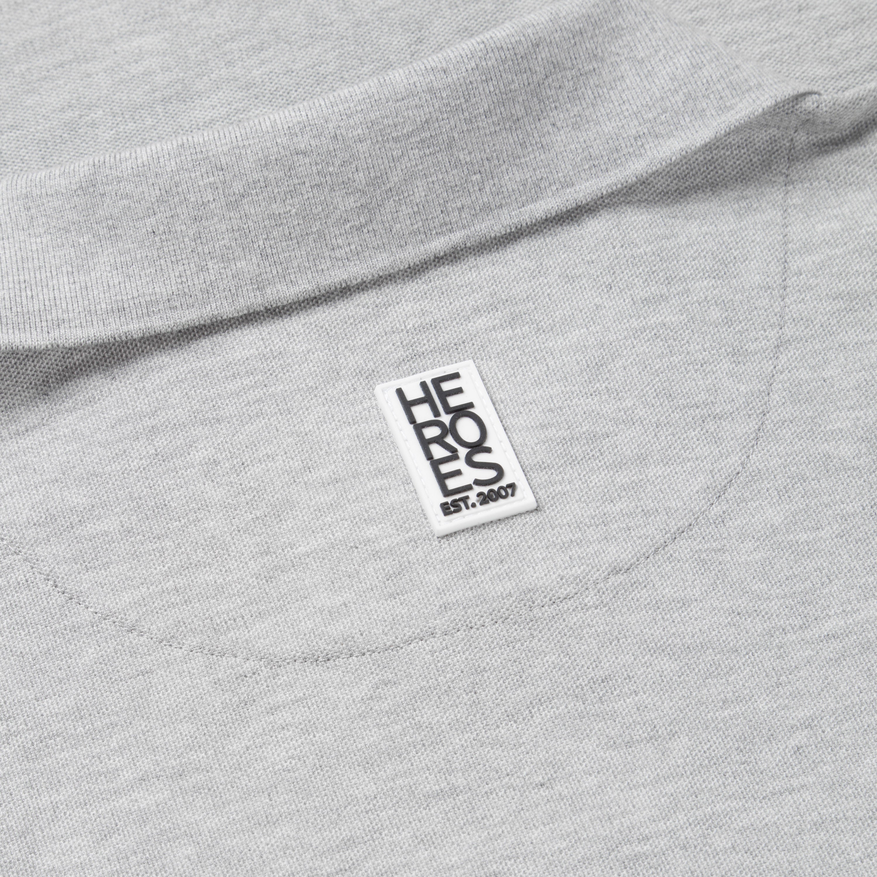 Close up image of rubber Help for Heroes logo on back neck of the grey marl pique polo shirt