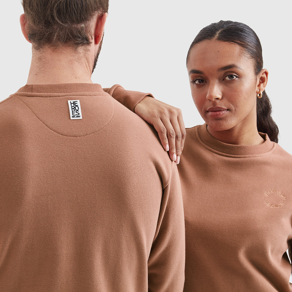 Two models wearing crew neck Help for Heroes sweatshirts in mocha, featuring an embroidered circular Help for Heroes logo on the chest and a rubber Heroes rubber logo on the back neck