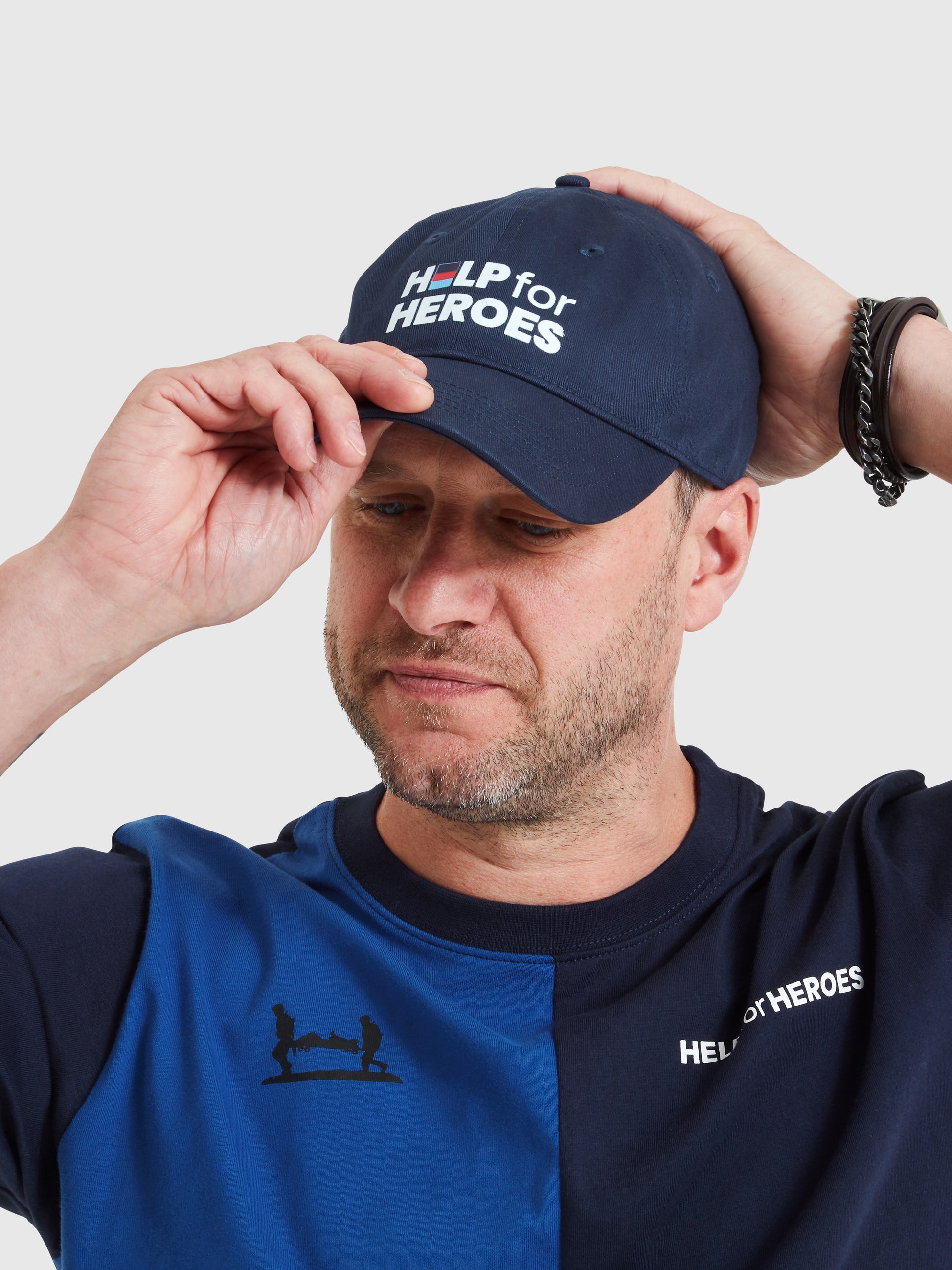 Model wearing Navy baseball cap with Help for Heroes logo printed on the front