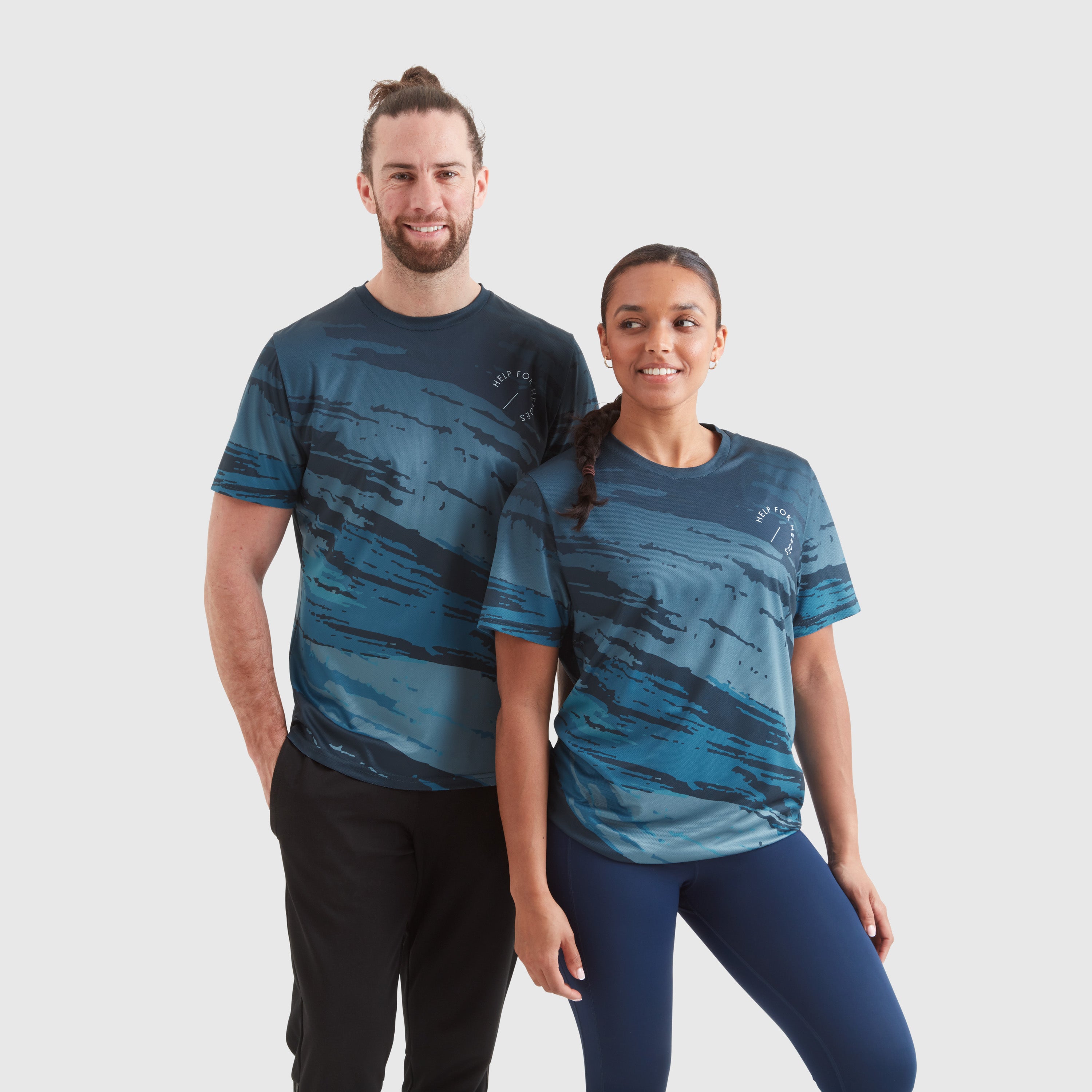 Two models wearing a blue ombre stripe sport leisure t-shirt, with a circular Help for Heroes logo on the chest