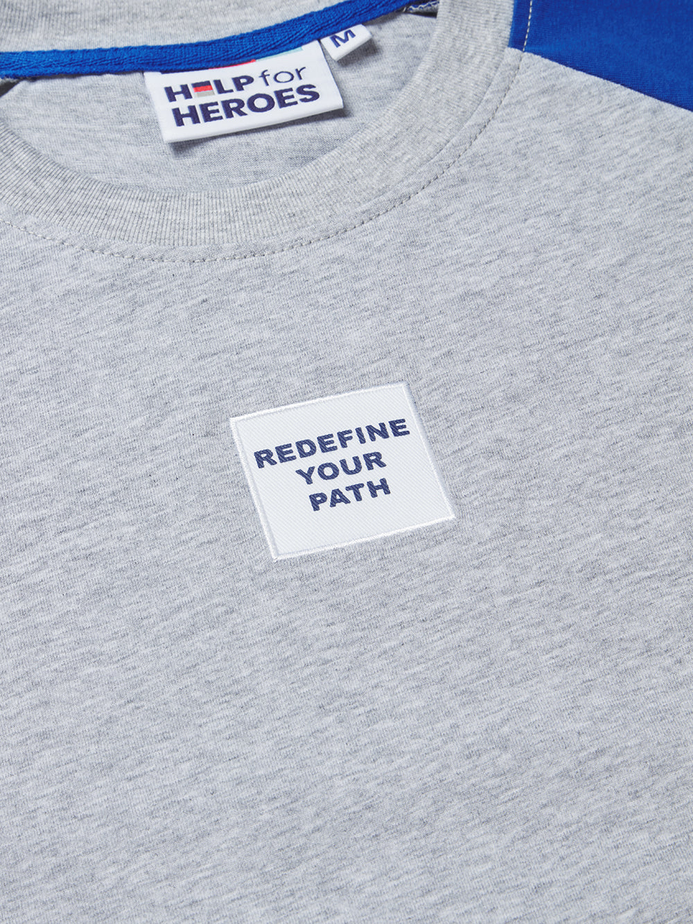 Close up image if "redefine your path" chest patch on the contrasting sleeve Help for Heroes tshirt