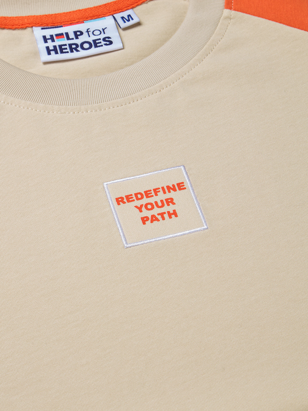 Close up image if "redefine your path" chest patch on the contrasting sleeve Help for Heroes tshirt