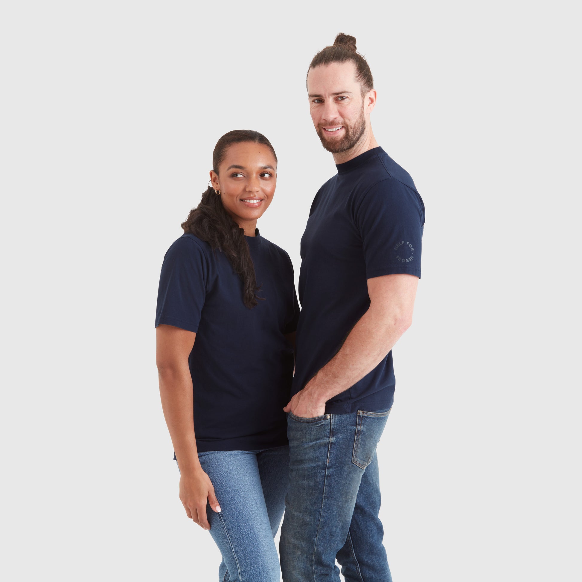 Models wearing a navy blue crew neck t-shirt with a "redefine your path" contrast slogan mountain back print in orange. Featuring a circular Help for Heroes logo on the sleeve