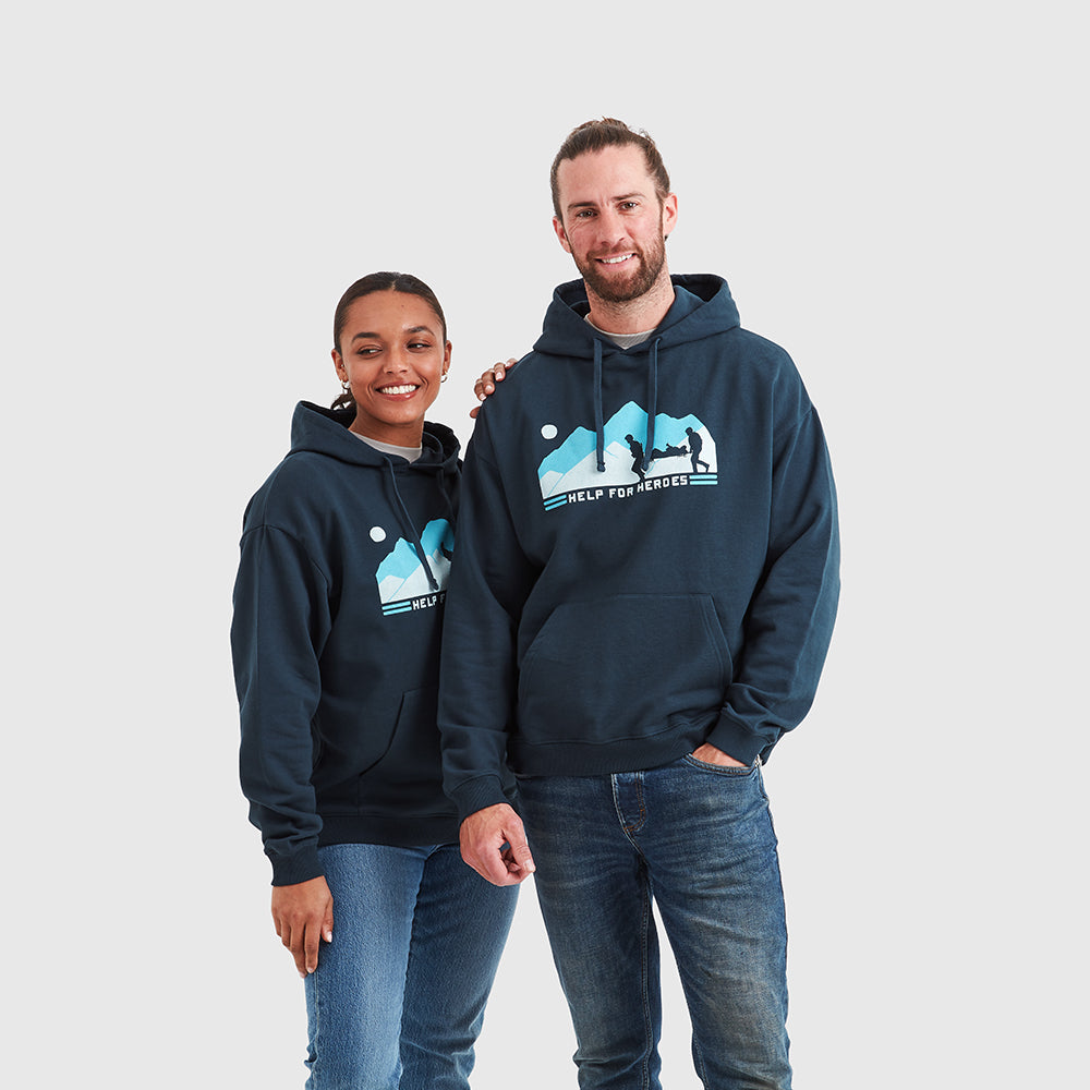 Two models wearing navy pullover Help for Heroes hoodies, featuring the stretcher bearer logo