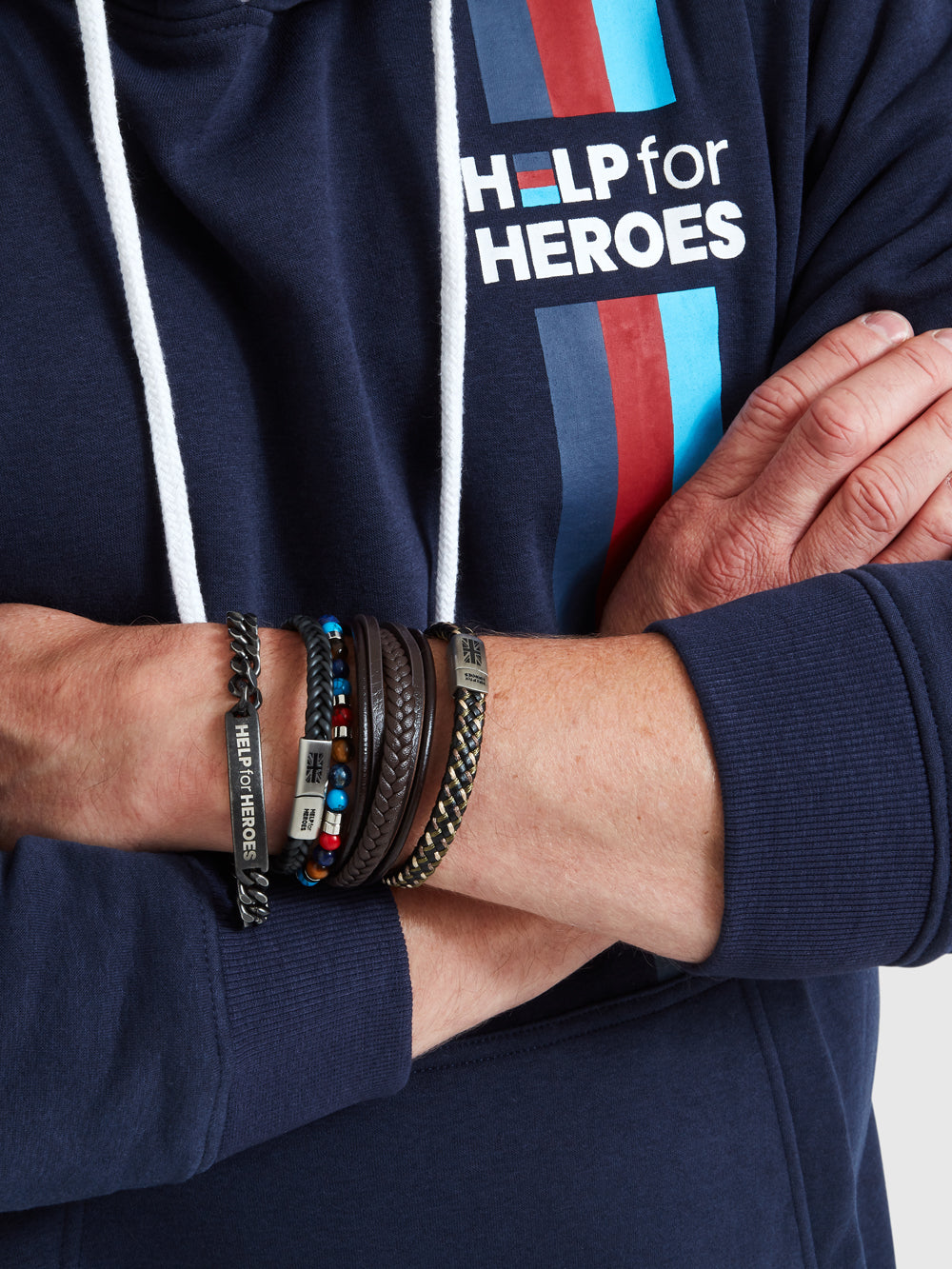 A collection of Help for heroes wristbands worn on a model, featuring camo plaited, tri colour beads and gunmetal