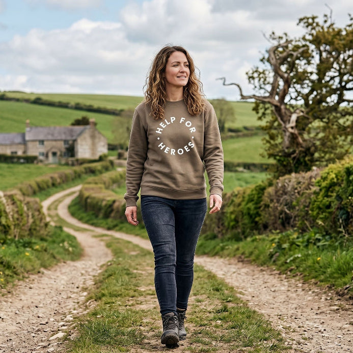 Woman wearing a soft brown Help for Heroes sweatshirt walking up a country lane
