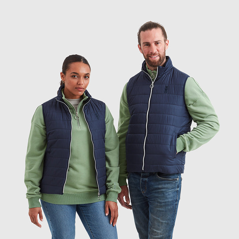 Two models wearing navy padded gilets, featuring metal zip and embroidered Help for Heroes logo on the chest