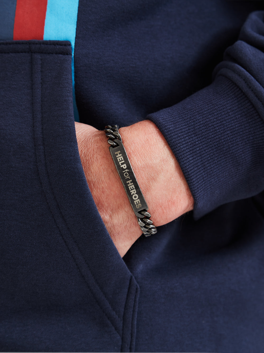 Help for heroes gunmetal silver wristband, with logo in the middle, worn on model's wrist