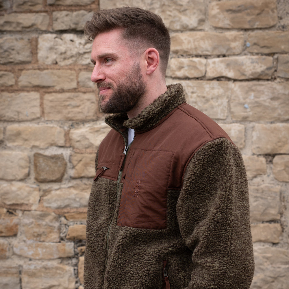 Model wearing heavyweight fleece jacket in brown, featuring chest pockets and Help for Heroes logo