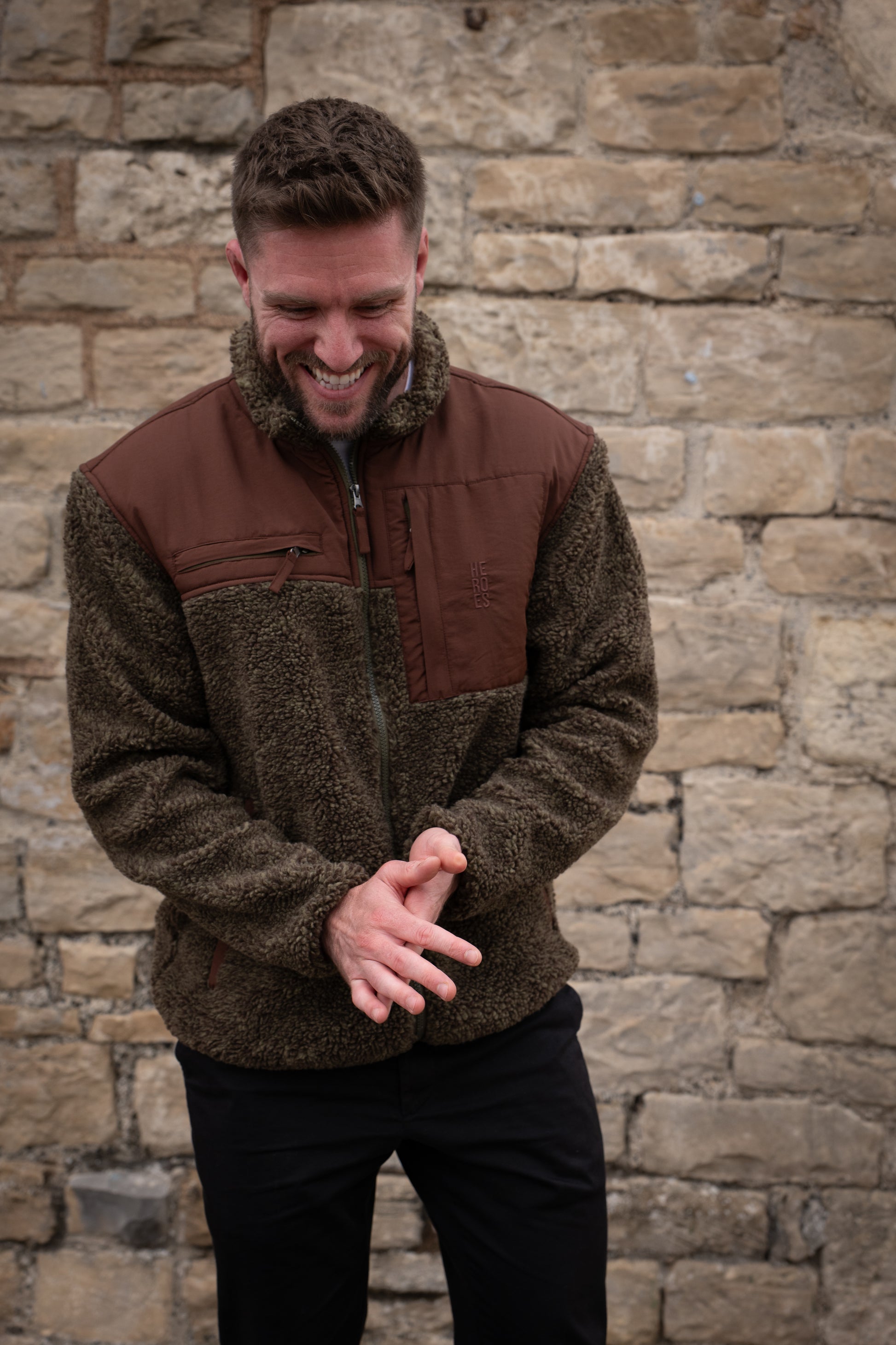 Model wearing heavyweight fleece jacket in brown, featuring chest pockets and Help for Heroes logo