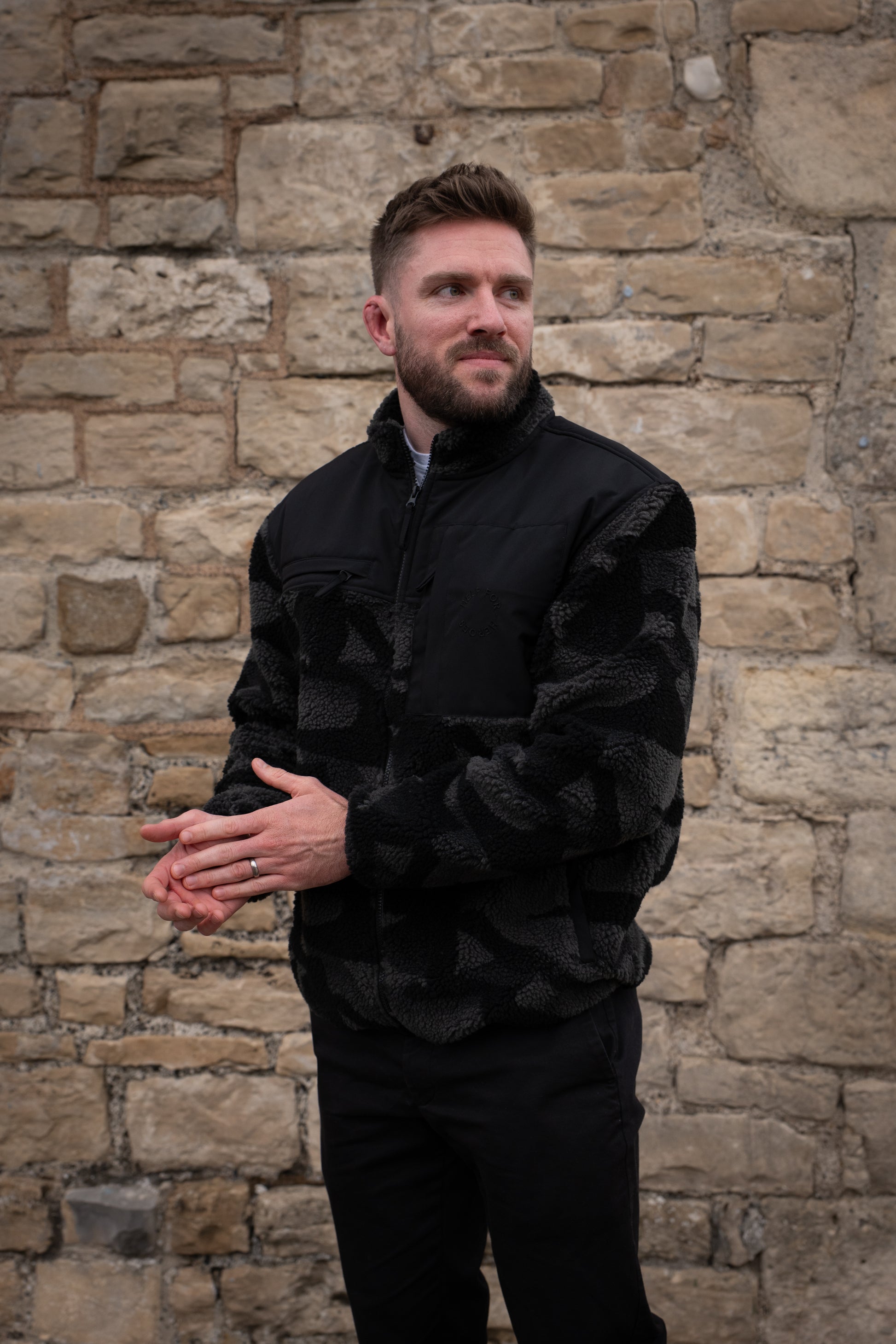 Model wearing heavyweight fleece jacket in grey camo, featuring chest pockets and Help for Heroes logo