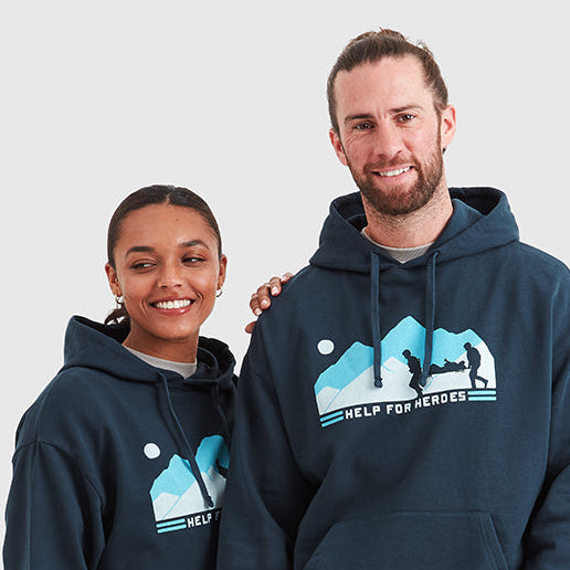 Two models wearing navy Help for Heroes hoodies, featuring the stretcher bearer logo