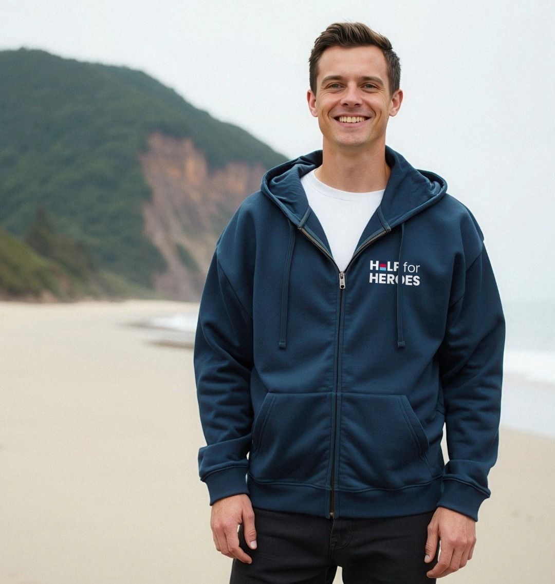 Man wearing a Help for Heroes navy blue hoodie with a logo on a beach