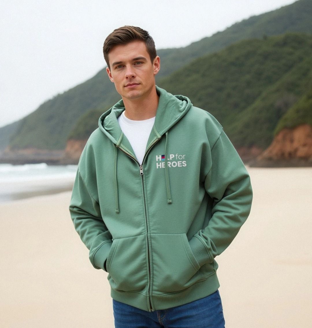 Man wearing a surf green hoodie with 'Help for Heroes' logo on a beach